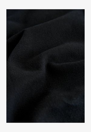 Must kangas pehme ja sileda tekstuuriga, kergete voldikute ja lainetega, rõhutades ühtlast värvi ja viimistlust.