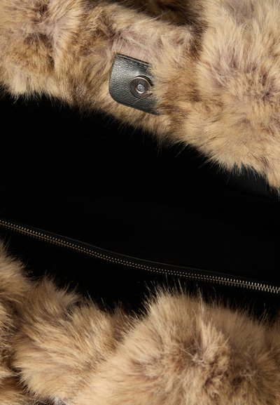 Faux fur handbag interior in light brown, featuring a black zipper and a leather tab with a button snap. Soft texture and spacious design.