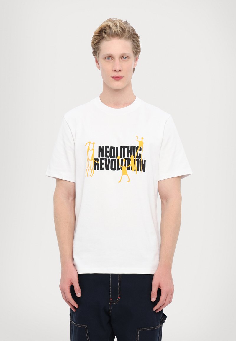 Tricou alb din bumbac, cu text negru și galben "Revoluția Neolitică" și figuri abstracte. Guler rotund, mâneci scurte, croială degajată.