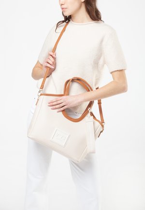 Borsa beige realizzata in materiale sintetico testurizzato, manico in finta pelle marrone, tracolla staccabile e patch con logo. Caratteristiche di design eleganti.