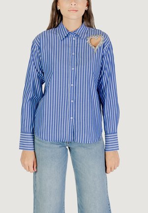 Camisa de manga larga a rayas azul y blanca con botón en el frente, que presenta un adorno en forma de corazón en el pecho y mangas con puños.