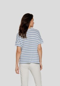 Striped knit top featuring blue and white horizontal stripes, short sleeves, relaxed fit, with a subtle ribbed texture.