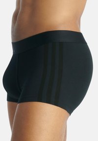 Svarta boxer briefs med ett slätt, elastiskt tyg. Har en bred midja och tre mörka ränder på sidan för extra detalj.