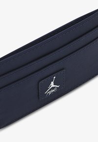 Portafoglio in nylon blu navy con un design elegante, logo Jumpman in rilievo e dettagli di cucitura sottili. Forma compatta per una facile conservazione.