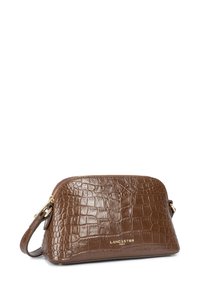 Sac en cuir embossé crocodile brun avec une fermeture zippée, de forme incurvée et un logo en ton doré à l'avant. Poignée ajustable incluse.