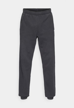 Donkergrijze joggingbroek met elastische tailleband, taps toelopende pijpen en geribbelde boorden. Voorzien van zijzakken en een subtiel logodetail aan de zijkant.