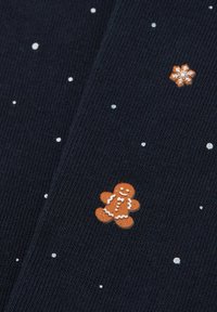 Mörkblå stickad tyg med vita snöflinge- och prickmönster, med broderier av orange och bruna pepparkaksgubbar och snöflingor.