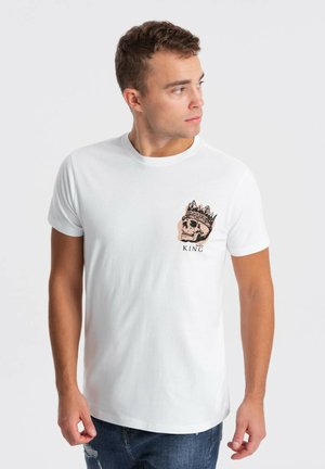 Hvid bomulds-t-shirt med et frontgrafik af et skelet med en krone og "KING" tekst. Korte ærmer, rund halsudskæring, afslappet pasform.