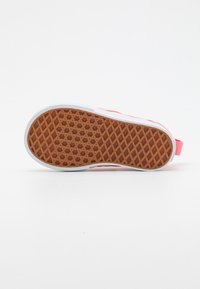 Suela de zapato con material de goma, patrón hexagonal, bordes blancos y un acento rosa en la parte posterior. Diseño plano y flexible.