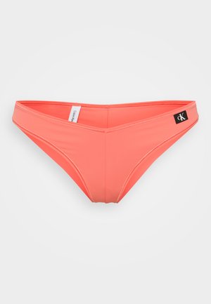 Bas de bikini corail avec une texture lisse, présentant un design minimaliste, des côtés étroits et une étiquette logo noire sur la hanche droite.