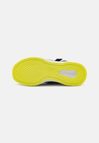Sole di sneaker multicolore con una suola in gomma gialla caratterizzata da un motivo testurizzato, una intersuola bianca e un accento nero.