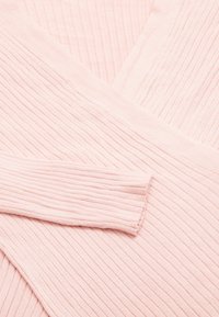 Pulover roz deschis cu o textură cu nervuri, design în formă de V și mâneci lungi, cu o suprafață netedă și material moale.