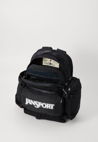 Zwarte rugzak met meerdere vakken, een voorvak met rits, en een groot hoofdvak met een mesh-inzet. Jansport-logo zichtbaar.