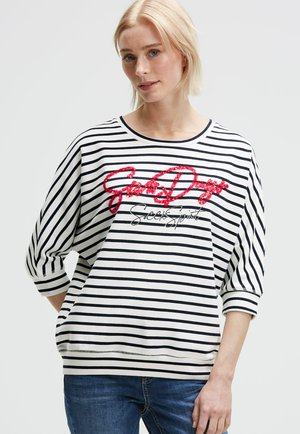 Striped sweatshirt in white and navy with 3/4 sleeves, featuring red glitter text and casual fit. Soft material with round neckline.