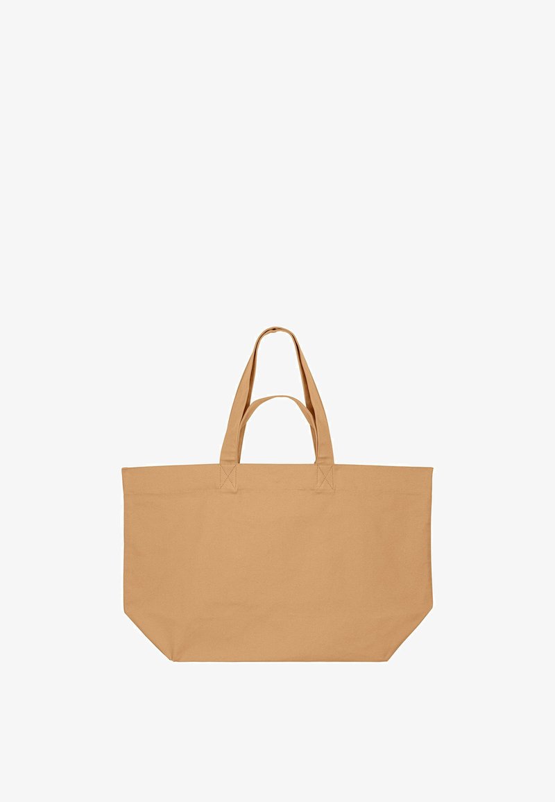 Grand sac fourre-tout rectangulaire en toile beige avec deux poignées courtes et une longue, conçu pour être porté à la main ou à l'épaule.