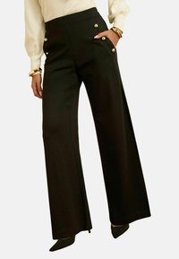 Pantalones negros de pierna ancha con detalles de botones dorados en los bolsillos. Fabricados con tela suave, corte ajustado, cintura alta y piernas rectas.