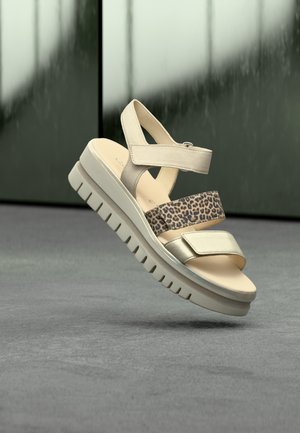 Beige plateau sandalen met een gladde afwerking, voorzien van banden met dierenprint, verstelbare gespen en een geribbelde zool voor grip.