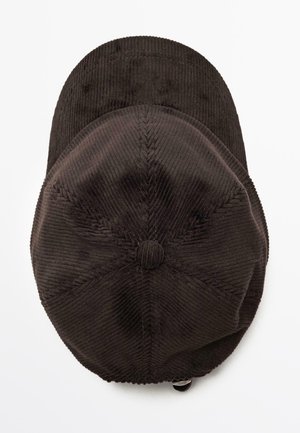 Donkerbruine corduroy pet met een ronde bovenkant, zichtbare stiksels en een kleine knop op de kroon. Verstelbare band aan de achterkant.