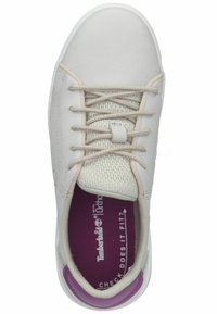 Vit sneaker med beige snören, meshtunga, lila innersula och Timberland-logga inuti, sedd uppifrån.