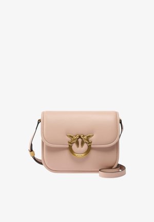 Borsa a tracolla in pelle rosa con chiusura a patta, decorazione a forma di uccello in tono oro e tracolla regolabile. Texture liscia e design semplice.