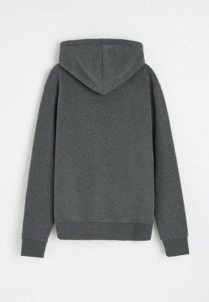 Szara bluza z kapturem, wykonana z miękkiej, teksturowanej tkaniny. Posiada luźny krój, długie rękawy oraz ściągacze przy mankietach i u dołu. Pokazany widok z tyłu.