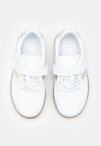 Weiße Leder-Sneaker mit einem Klettverschluss, die eine glatte Oberfläche und eine hellbraune Gummisohle, Schnürsenkel sowie dezente silberne Akzente an den Seiten aufweisen.