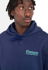 Sudadera de color azul marino hecha de tela suave, con capucha ajustable y un logo "Element" turquesa en el pecho. Diseño sencillo y corte casual.
