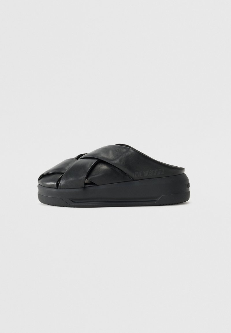 Sandale noire à enfiler avec semelle épaisse rembourrée et brides croisées en cuir rembourré, marquée "Love Moschino" sur le côté et au talon.