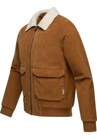 Ruskea corduroy-takki, jossa on vaalea shearling-kaulus. Ominaisuuksiin kuuluvat kaksi etupusseja ja vetoketjukiinnitys. Pehmeä pinta, ribatoitumiset yksityiskohdat.