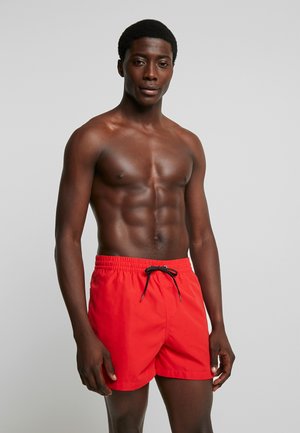 Bañador rojo con cintura elástica, cordón ajustable negro y una textura suave, que presenta un corte clásico y deportivo.