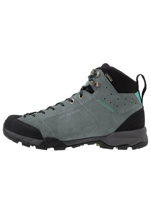 Grå og sort vandrestøvle i mellem højder med snørehager, Gore-Tex mærke, robust sål og polstret ankelkrave, designet til udendørs brug.