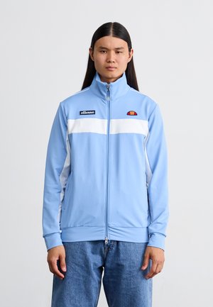 Giacca da track leggera di colore azzurro con zip, con una striscia orizzontale bianca. Presenta un colletto alto, un logo sul petto sinistro e due tasche laterali.