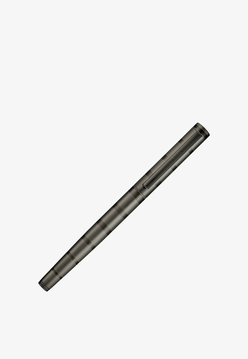 Stylo en métal noir mat avec de subtiles rainures horizontales et un clip gravé "Hugo Boss" sur un fond blanc.