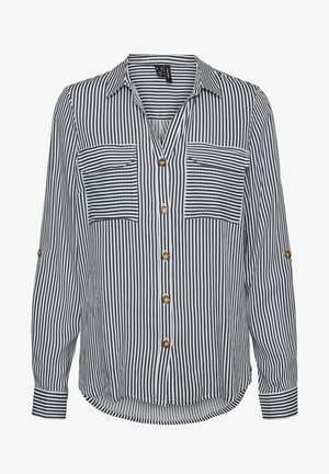 Stripet skjorte i marineblå og hvit, med to brystlommer, knappefester og oppbrettbare ermer. Glatt struktur med en avslappet passform.