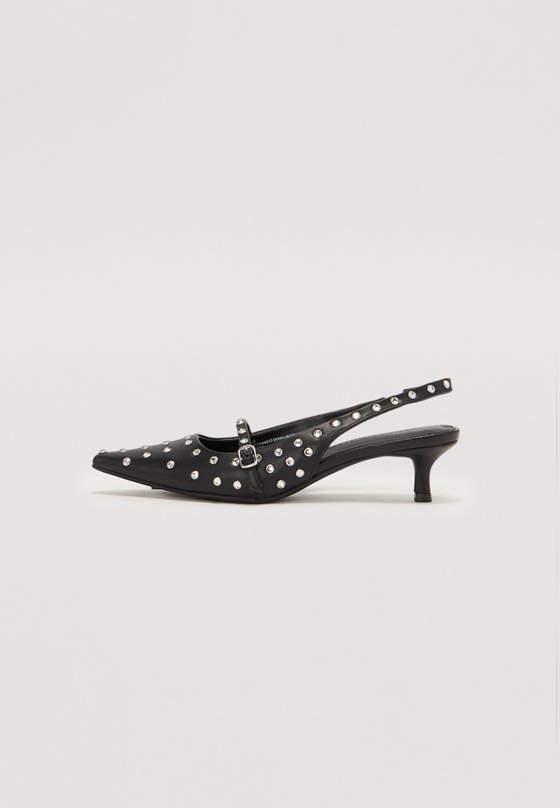 Chaussure à talon kitten slingback pointue noire avec clous argentés et une petite bride à boucle sur le dessus.