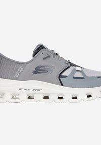 Zapatilla deportiva gris con parte superior de malla, sistema de lazado seguro y suela blanca acolchada con múltiples orificios de ventilación.