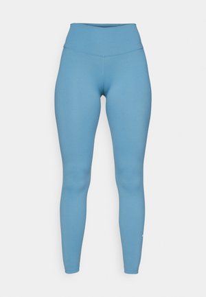Leggings altos de cintura en azul, hechos de un tejido elástico. Diseño ajustado y estilizado con una textura suave y un discreto detalle de logo en la parte inferior de la pierna.