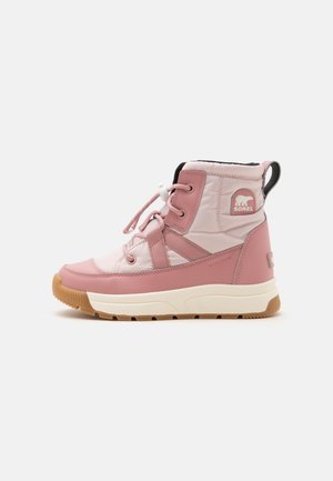 Botte d'hiver montante rose et beige clair avec semelle en caoutchouc, patch logo latéral, fermeture à lacets et tirette sur fond blanc.