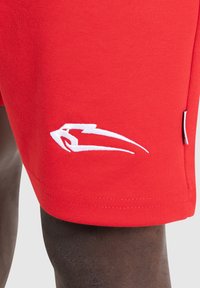 Rode sportieve shorts gemaakt van een mix van katoen. Kenmerkt zich door een witte gestileerde logo op het linkerpijpje en een zijlabel. Gladde textuur, op maat gemaakte pasvorm.