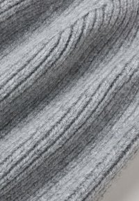 Knitted gray wool fabric with a ribbed texture. Features alternating raised and recessed stripes, showcasing softness and warmth.