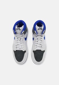 Zapatillas altas con un exterior de ante gris, acentos azules, detalles perforados y cordones blancos. Logotipo "ZOOM AIR" en la lengüeta.