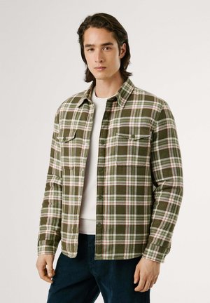Groen en wit geruite flanellen shirt met rode accenten; met knopen aan de voorkant, twee borstzakken en een geknoopt halsomslag.
