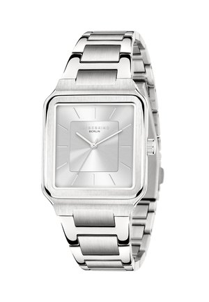 Sølv rektangulært ur med et børstet metalarmbånd. Har en struktureret sølvskive, minimalistiske visere og et diskret brandlogo.