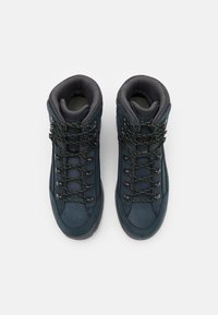 Mörkblå vandringsskor med gröna och svarta snören, vadderade kragar och texturerade gummisulor. Har förstärkta tåskydd och öglor.