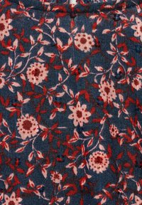 Blommigt bomullstyg med en mörkblå bakgrund; har rosa och röda blommor med gröna blad, vilket skapar en texturerad, mönstrad design.