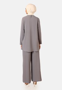 Gray, textured two-piece outfit with long sleeves and wide-leg pants, featuring a small button closure at the back and a coordinating hijab.