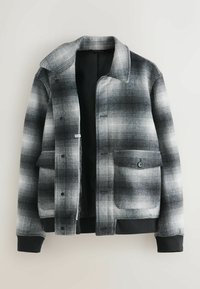 Grå og sort ternet jakke med knappelukning foran, to forlommer og ribstrikkede manchetter. Lavet af tekstureret stof med en struktureret krave.