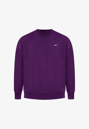 Fioletowy sweter z okrągłym dekoltem, z prążkowanym kołnierzem, mankietami i dołem. Posiada małą metkę z logo z przodu. Wykonany z miękkiego materiału.