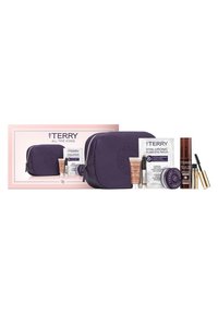 Lila Lederkosmetiktasche mit geprägt Logo, begleitet von Hautpflege- und Make-up-Produkten in verschiedenen Behältern, vor einem pinken Kasten.