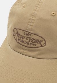 Căciulă de baseball kaki cu text brodat maroniu "1991 New York World's City" pe panoul din față.